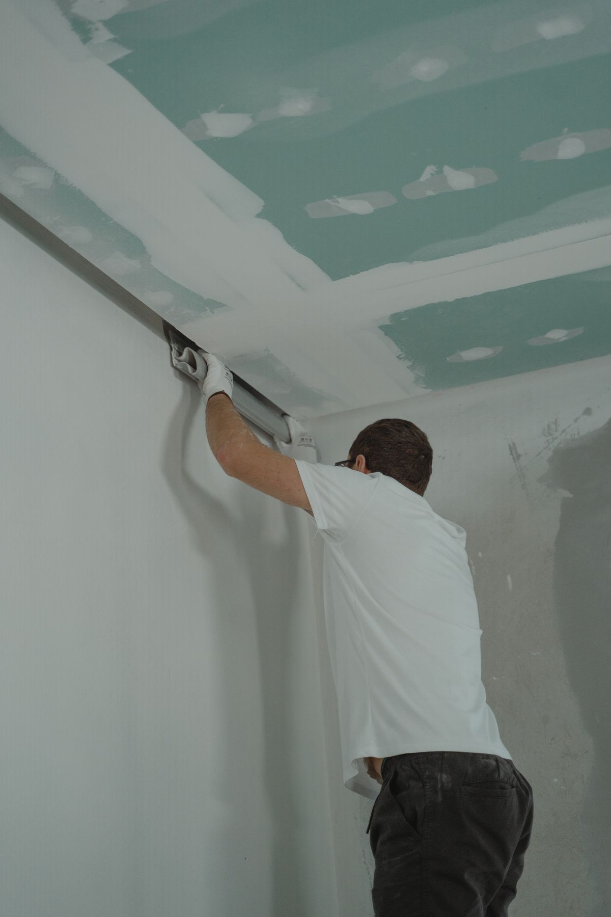 New drywall being installed and taped, the covering approach used on painted or asbestos-positive popcorn ceilings