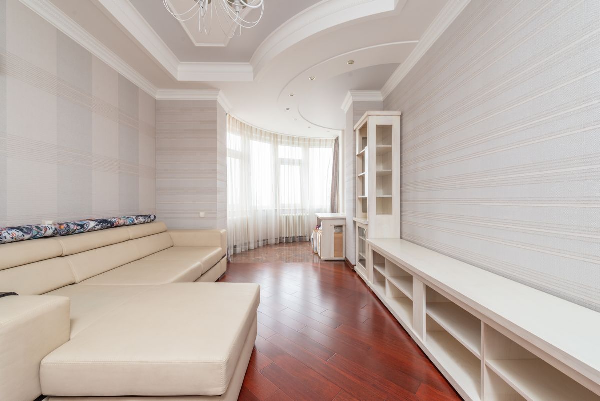 Bright living room with a smooth, freshly finished ceiling after texture removal